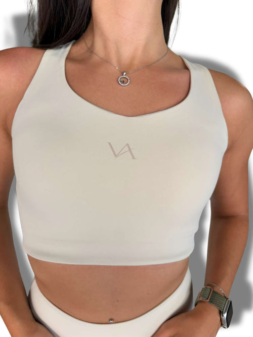 Top deportivo mujer Flow Top VA color Pearl Champagne, detalle logo bordado en pecho