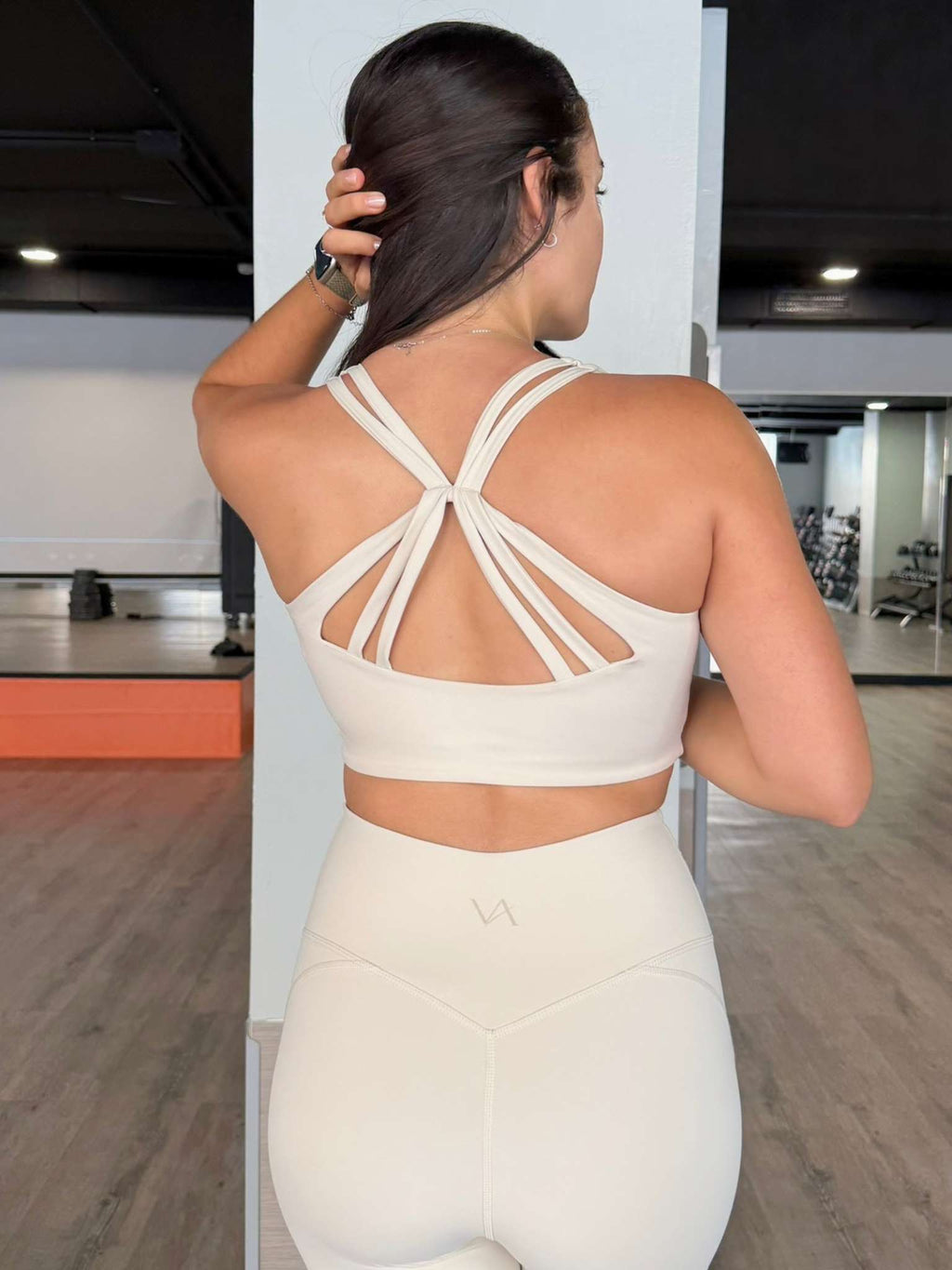 Mujer con top deportivo elegante y legging a juego VA, look completo studio-to-street